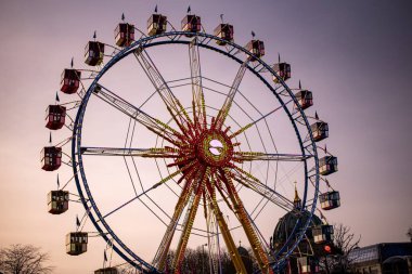 Berlin Dönme dolabı parlak ışıklarla parıldıyor. Şehrin gökyüzü ve gece boyunca büyüleyici bir atmosfer manzarası sunuyor..