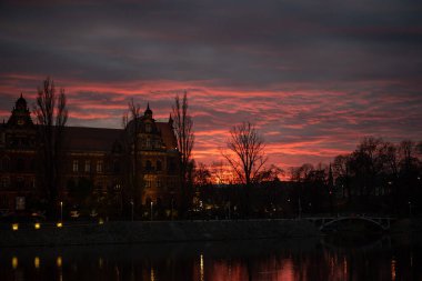 Wroclaw 'daki Ulusal Müze' nin üstündeki inanılmaz günbatımı gökyüzü tarihi binanın üzerine sıcak bir ışık saçıyor, mimari güzelliğini arttırıyor ve büyülü bir atmosfer yaratıyor..