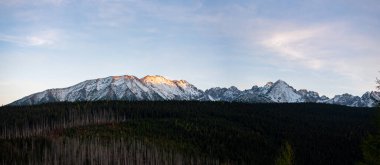 Polonya 'nın Zakopane kentindeki Kopieniec Dağı' nın tepesinde gün batımı, Tatra Dağları 'nın üzerine sıcak bir ışık saçıyor. Canlı renkleri ve nefes kesici manzaralarıyla doğa severleri büyüleyen çarpıcı bir manzara yaratıyor..