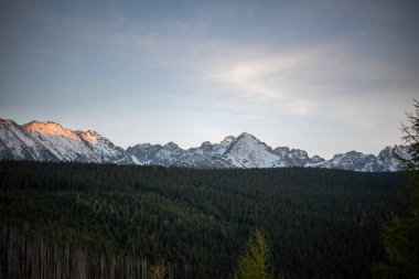 The sunset atop Mount Kopieniec in Zakopane, Poland, casts a warm glow over the Tatra Mountains, creating a stunning landscape that captivates nature lovers with its vibrant colors and breathtaking views. clipart