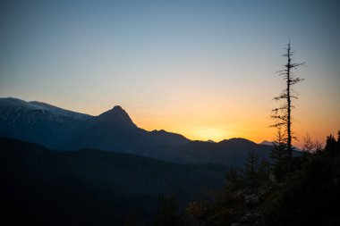 Polonya 'nın Zakopane kentindeki Kopieniec Dağı' nın tepesinde gün batımı, Tatra Dağları 'nın üzerine sıcak bir ışık saçıyor. Canlı renkleri ve nefes kesici manzaralarıyla doğa severleri büyüleyen çarpıcı bir manzara yaratıyor..