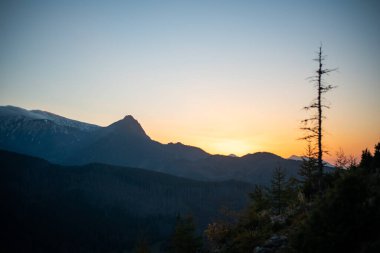 The sunset atop Mount Kopieniec in Zakopane, Poland, casts a warm glow over the Tatra Mountains, creating a stunning landscape that captivates nature lovers with its vibrant colors and breathtaking views. clipart