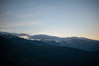 Polonya 'nın Zakopane kentindeki Kopieniec Dağı' nın tepesinde gün batımı, Tatra Dağları 'nın üzerine sıcak bir ışık saçıyor. Canlı renkleri ve nefes kesici manzaralarıyla doğa severleri büyüleyen çarpıcı bir manzara yaratıyor..