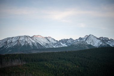 The sunset atop Mount Kopieniec in Zakopane, Poland, casts a warm glow over the Tatra Mountains, creating a stunning landscape that captivates nature lovers with its vibrant colors and breathtaking views. clipart