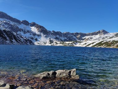 Polonya 'nın Tatra Dağları, Beş Göl Vadisi' ndeki benzersiz bir göl manzarası engebeli tepeler ve yemyeşil yeşilliklerle çevrili çarpıcı bir dağ güzelliğini gözler önüne seriyor.