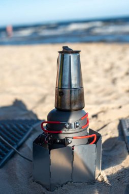 Açık havada kahve hazırlamak, doğa ile çevrili, kamp ve maceranın özünü yakalar, manzaranın ortasında sıcak bir içecek sunar..