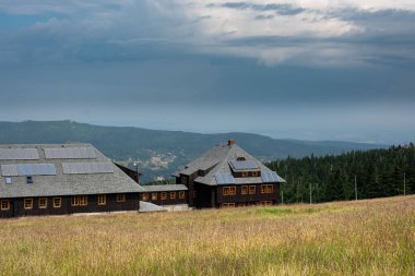 The mountain shelter atop Szrenica peak in the Karkonosze offers a cozy retreat with stunning alpine views clipart