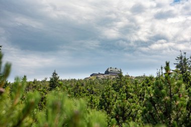 The mountain shelter atop Szrenica peak in the Karkonosze offers a cozy retreat with stunning alpine views clipart