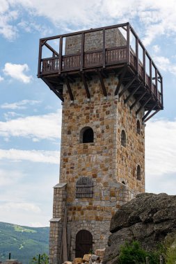 Wysoki Kamien 'in zirvesi Jizera Dağları' nın 1058 metre yüksekliğinde, bir kule tarafından taçlandırılmış, geniş bir dağ manzarası sunuyor.