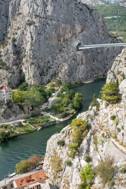 Hırvatistan 'daki Cetina Nehri boyunca uzanan Omis köprüsünde manzara tünelleri ve dağ manzaralı bir köprü yer alıyor.