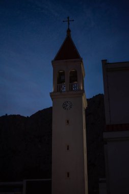 Night view of Omis city, Croatia, with illuminated streets and the scenic backdrop of the mountains. clipart