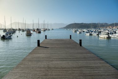 Şair Körfezi 'ne bakan eski ahşap iskele (Golfo dei poeti) - sakin deniz ve bir sürü demirli tekne. Lerici, Liguria, İtalya