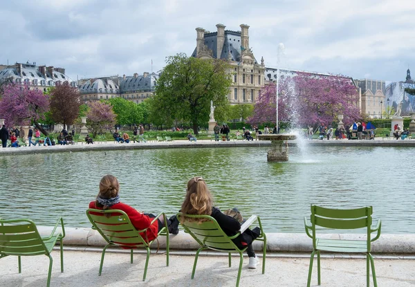 stock image Paris, France - April 24 2023: Two young girls seated in front of the fountains of the Tuileries Garden in Paris in springtime - Jardin des Tuileries Tourists