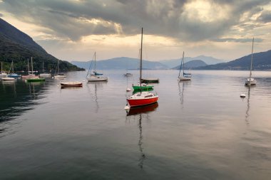 Serene Yelkenlileri İtalya Gölü 'nün sakin sularına yanaştı Puslu Tepeler ve Huzurlu Yansımalarla Huzurlu Manzara