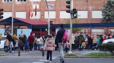 - Okul. Zaman atlaması okulu. Çocukların okula sabah ebeveynleri ve akrabaları eşliğinde girmesi. Madrid Üniversitesi, İspanya. Avrupa. Yatay video. MADRİD, İSPAN - 16 Kasım 2022.