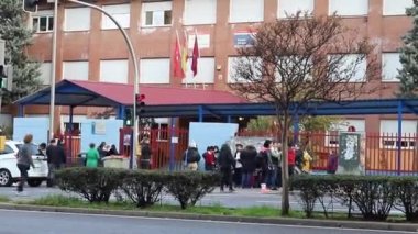 - Okul. Zaman atlaması okulu. Çocukların okula sabah ebeveynleri ve akrabaları eşliğinde girmesi. Madrid Üniversitesi, İspanya. Avrupa. Yatay video. MADRİD, İSPAN - 16 Kasım 2022.