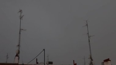 Şimşek. Madrid şehrinden geçen fırtınada gökyüzünün aydınlandığı ve yağmur ve dolu bıraktığı an. Yıldırım videosu. Ray!.