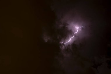 Ben Ray. Fırtına. Gökyüzü, büyük bir fırtına öncesi kötü hava koşullarında kara bulutlarla doludur. Bulutların kenarından ışık emisyonu. Kara bir sisin yüzeyini yakın mesafeden yakınlaştır.