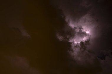 Ben Ray. Fırtına. Gökyüzü, büyük bir fırtına öncesi kötü hava koşullarında kara bulutlarla doludur. Bulutların kenarından ışık emisyonu. Kara bir sisin yüzeyini yakın mesafeden yakınlaştır.