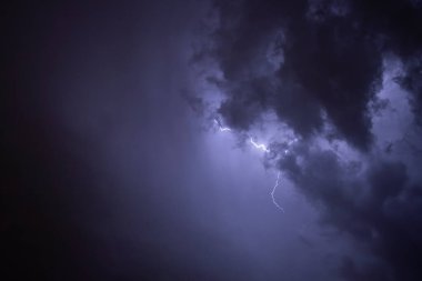 Ben Ray. Fırtına. Gökyüzü, büyük bir fırtına öncesi kötü hava koşullarında kara bulutlarla doludur. Bulutların kenarından ışık emisyonu. Kara bir sisin yüzeyini yakın mesafeden yakınlaştır.
