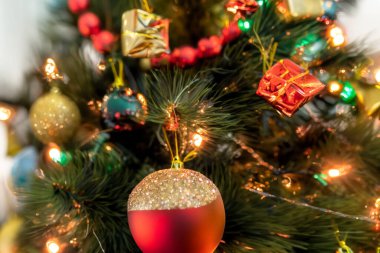 Noel zamanı. Noel ağacı arkaplanı. Noel süsü. Odadaki köknar ağacının yanında yerde duran güzel hediye kutuları. Parlak tatil kompozisyonu. 2023. Aralık.
