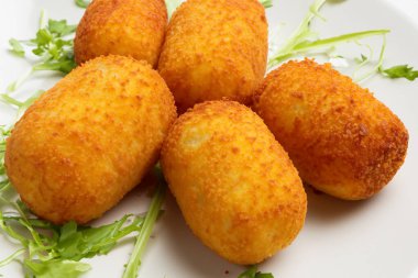 Kroket. Bir tabak kroket. Geleneksel İspanyol ev yapımı kroketler ya da çatallı beyaz tabakta kroketler. Tapas yemeği. Uluslararası Kroket Günü. 16 Ocak. 2024