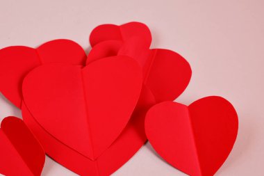 Sevgililer Günü. Kırmızı kalp tasarımı. 14 Şubat. 2024. Kırmızı sevgililer günü geçmişin kutlu olsun. Pembe arka planda 3 boyutlu kırmızı kalpler. Kağıt stili. Metin için yer.
