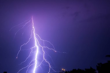 Ben Ray. Şimşek. Elektrik fırtınası. Yıldırım ve gök gürültülü güçlü bir elektrik fırtınası. Tarlalar üzerinde elektrik fırtınası. Yıldırım fotoğrafçılığı. Binaların ve ağaçların silueti.
