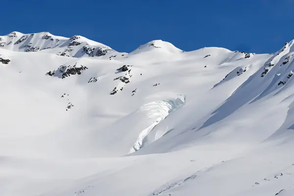 Snow avalanche. Swiss Alps. Snow avalanche in the mountains. Massive avalanche mountains.