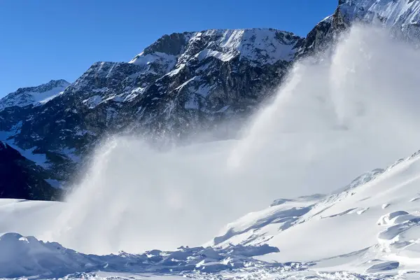 Snow avalanche. Swiss Alps. Snow avalanche in the mountains. Massive avalanche mountains.