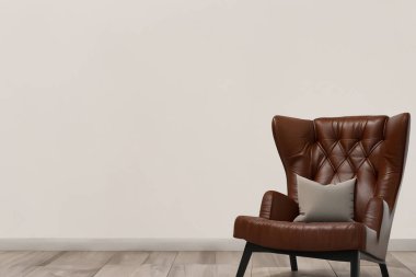 Oturma odası. Boş duvar arkası deri koltuklu oturma odası. Modern oturma odasının içinde siyah deri koltuk ve lamba var. Kanepesi ve sehpası olan modern oturma odası..