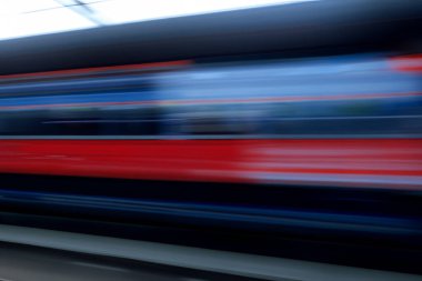 Tren. Modern yüksek hızlı tren istasyon platformunda hareket ediyor. Tren istasyonunun peronunda elektrikli tren var. Gün batımında demiryolu rayları. Demiryolu seyahat kavramı.