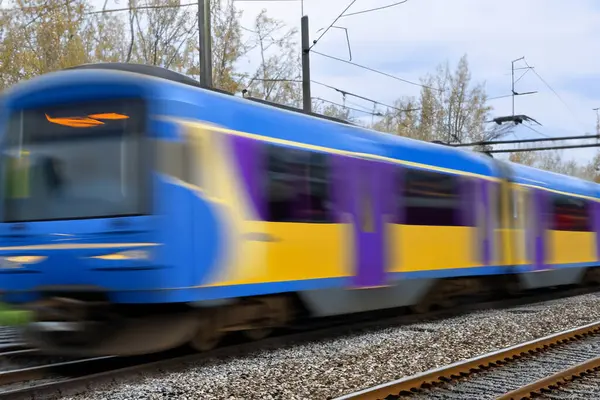 Tren. Modern yüksek hızlı tren istasyon platformunda hareket ediyor. Tren istasyonunun peronunda elektrikli tren var. Gün batımında demiryolu rayları. Demiryolu seyahat kavramı.