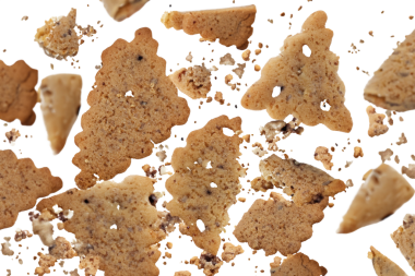 Cookie crumbs falling from above with isolated white background. Crumbs integral wholewheat biscuit with oatmeal, cookie flying, isolated on white, top view, clipping path. PNG format.