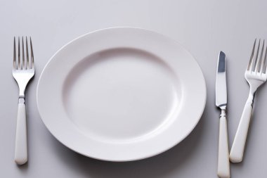 Tabak ve çatal bıçak takımı. Boş tabak ve çatal bıçak takımı dolu bir hayat. İzole edilmiş arka plan. Tahtaya ayrılmış çatal ve bıçakla dolu boş bir tabak. Tabaklı çatal, bıçak, çatal ve kaşık..