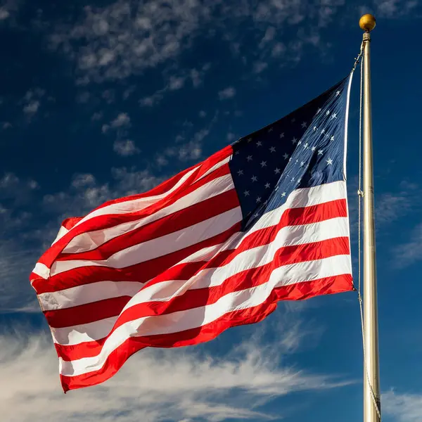 ABD bayrağı. 4 Temmuz. Parçalı bulutlu mavi gökyüzü rüzgarda dalgalanan Amerikan bayrağı. Chicago 'da arka planında gökdelenler olan ABD bayrağı. Bağımsızlık Günü kutlaması. 4 Temmuz kutlamaları.