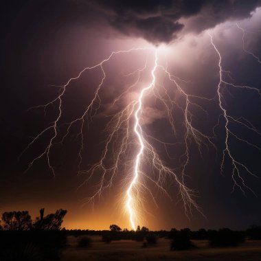 Lightning. Lightning strike. Spectacular night view of a lightning bolt streaking across the dark blue sky. Lightning and thunder and flashes. Clouds and silhouettes of trees are visible. Ireland. Eowyn.