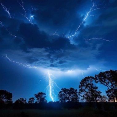Lightning. Lightning strike. Spectacular night view of a lightning bolt streaking across the dark blue sky. Lightning and thunder and flashes. Clouds and silhouettes of trees are visible. Ireland. Eowyn.
