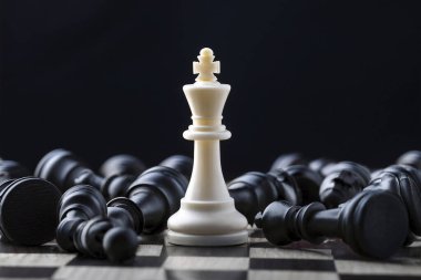 Satranç. Satranç tahtası. Patlamalar ve enkazlarla dramatik bir satranç sahnesi. Satranç taşlarıyla dolu boş bir alan. Siyah piyon ve siyah satranç tahtası arasında beyaz satranç kralı.