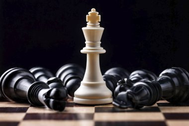 Satranç. Satranç tahtası. Patlamalar ve enkazlarla dramatik bir satranç sahnesi. Satranç taşlarıyla dolu boş bir alan. Siyah piyon ve siyah satranç tahtası arasında beyaz satranç kralı.