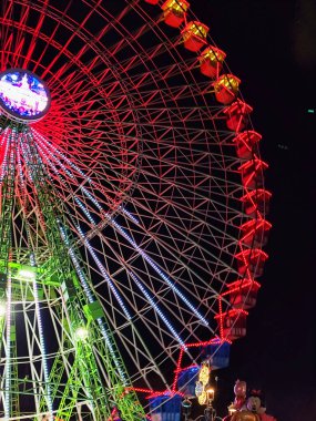 Ferris wheel. Noria. Christmas lights in Vigo, Pontevedra. Christmas decorations. Tourists strolling through its streets. Ferris wheel in the dark showing neon colors. VIGO. SPAIN. 13 December 2024. clipart