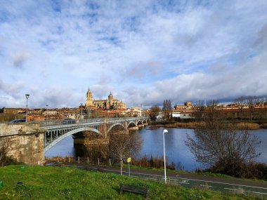 Salamanca. Tormes Nehri üzerindeki rıhtım noktasından Salamanca ve Enrique Estevan köprüsünün manzarası. Geleneksel taş binalar. Salamanca Katedrali. SALAMANCA, İSPAN. 13 Ocak 2025.