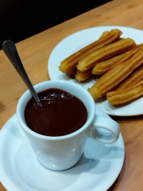 Çikolatalı churros. Çikolata soslu İspanyol churro. Bir fincan sıcak çikolata. Tipik İspanyol yemekleri.