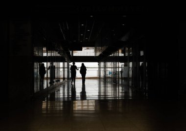 Şehir camlı galeri, ışığa karşı yürüyen iki kişi. Kentsel yalnızlığın kavramsal görüntüsü