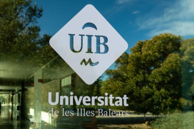 Palma de Mallorca, İspanya; 15 Aralık 2022: Balear Adaları Üniversitesi logosu, Uib, güneşli bir sabahta dış pencere camına damgalanmış. Mallorca Adası, İspanya