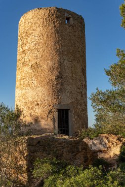 İspanya 'nın Mallorca adasında gün batımında terk edilmiş ve harap olmuş eski bir değirmen.