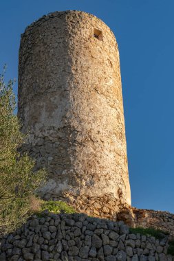İspanya 'nın Mallorca adasında gün batımında terk edilmiş ve harap olmuş eski bir değirmen.