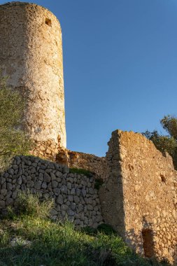 İspanya 'nın Mallorca adasında gün batımında terk edilmiş ve harap olmuş eski bir değirmen.