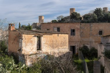 Arka planda eski taş değirmenleri olan terk edilmiş eski bir köy evi. Felanitx, Mallorca Adası, İspanya