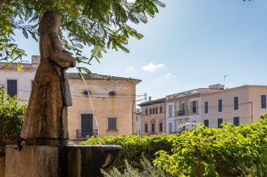 Felanitx, İspanya; Ocak 04 2022: Taştan heykel, Mallorca adasının tipik kostümüne sahip, sürahi suyu akan bir kadın heykeli. Felanitx, Mallorca Adası, İspanya